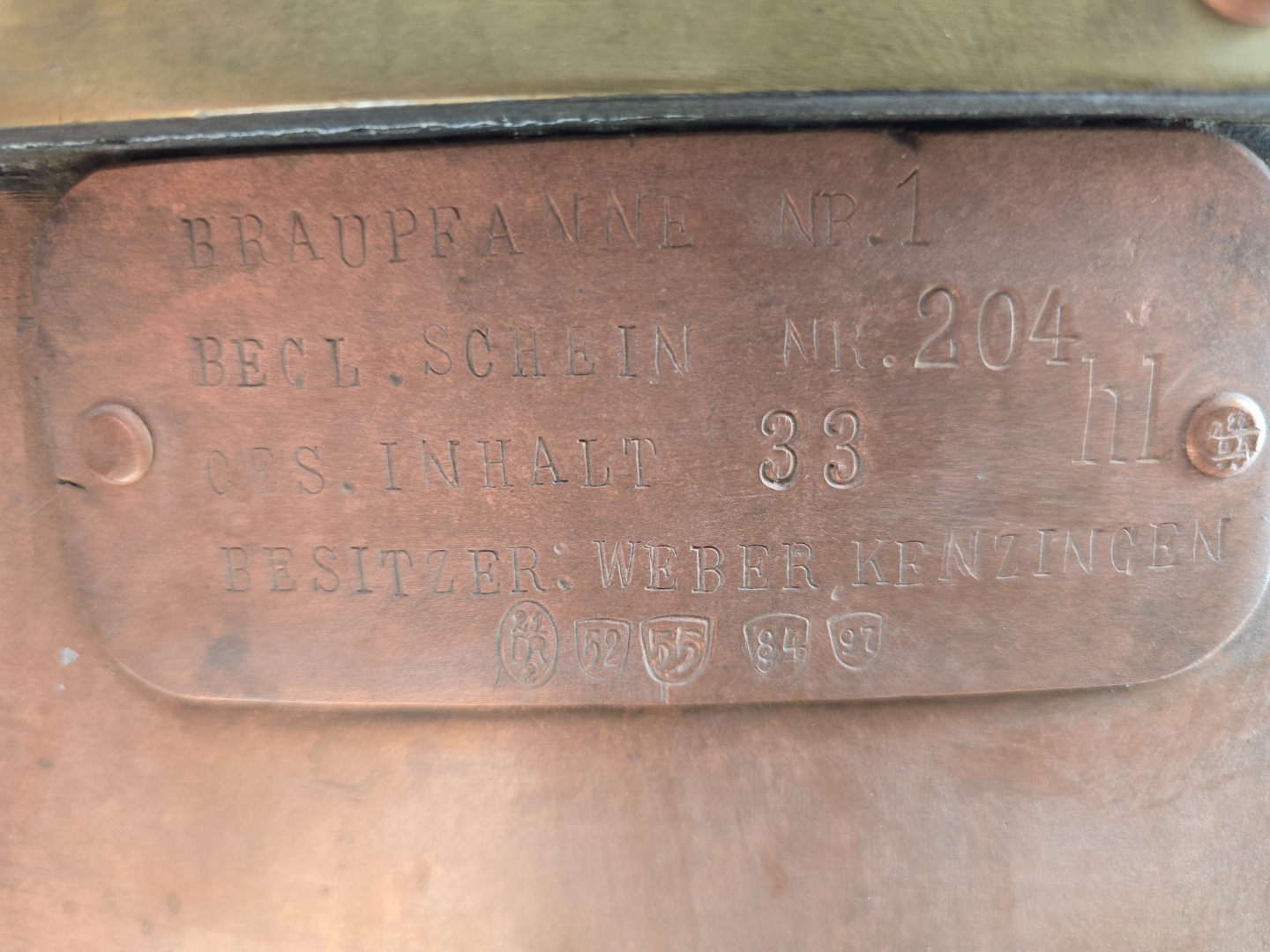 Close-up of the copper nameplate showing Braupfanne Nr. 1, Begl. Schein Nr. 204, Ges. Inhalt 33 hl, Besitzer: Weber Kenzingen, and five Eichamt inspection stamps