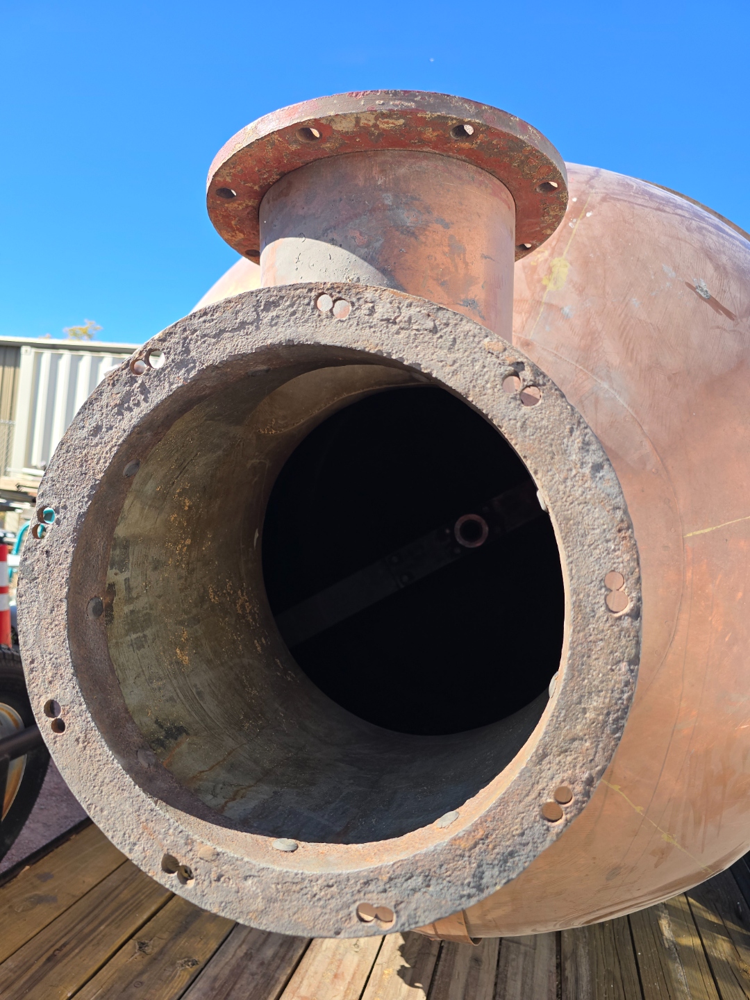 The large flanged opening of the copper kettle, showing the scale and craftsmanship